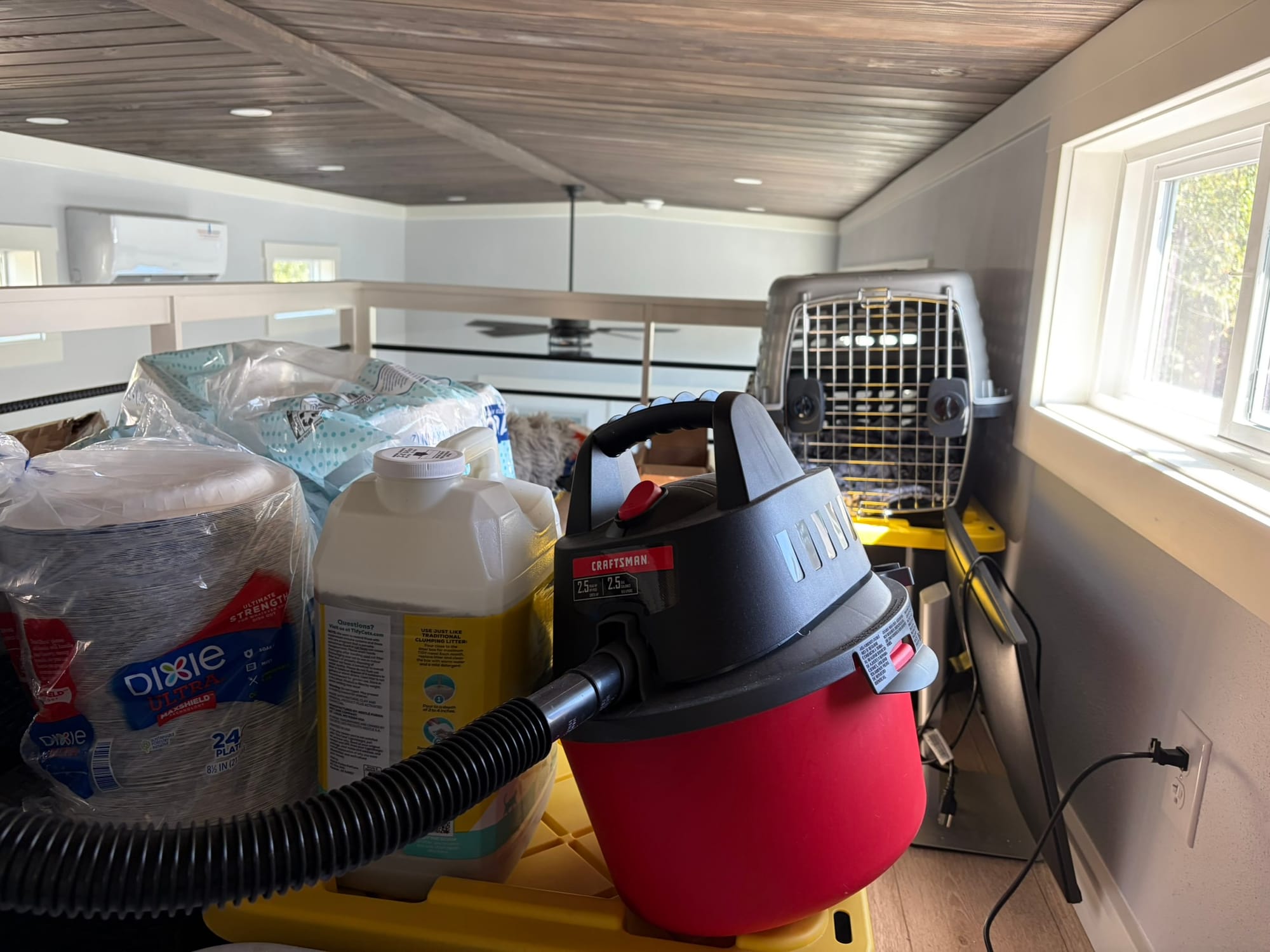 Small loft storage area in tiny house with boxes and supplies organized